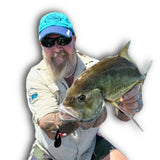 Angler holding large fish caught using a black handcrafted fishing lure